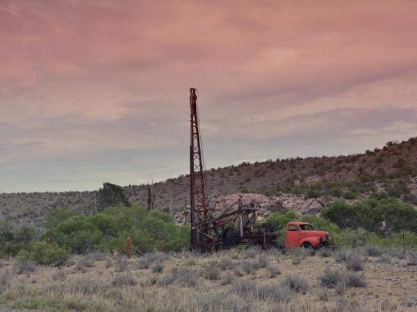 Truck and well drilling equipment in desert landscape