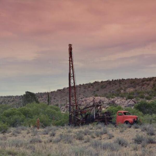 Truck and well drilling equipment in desert landscape